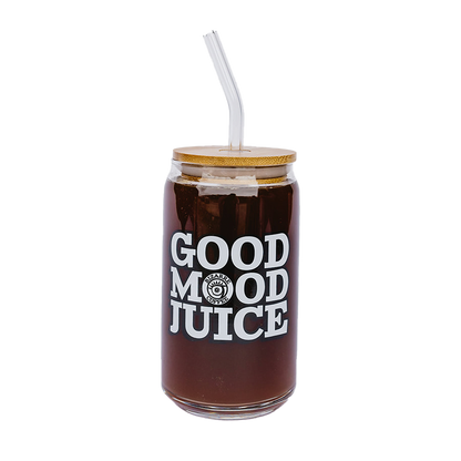 A glass cup that says Good Mood Juice and has a bamboo lid with a glass straw.